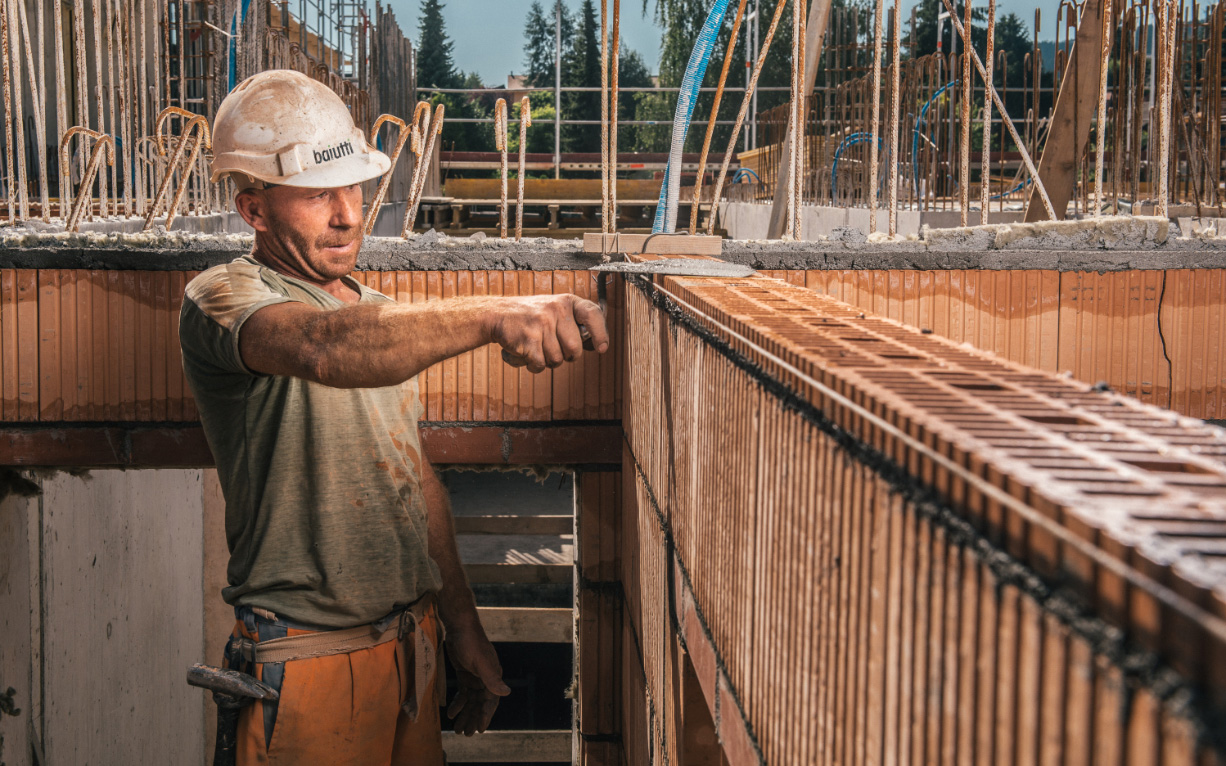 Homme au travail en train de maçonnener sur un chantier d'Enrico Baiutti SA.